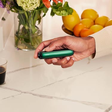 Ruka drží zařízení Ploom s předním panelem Amazon Green