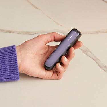 Ruka drží Ploom AURA s předním panelem Lavender