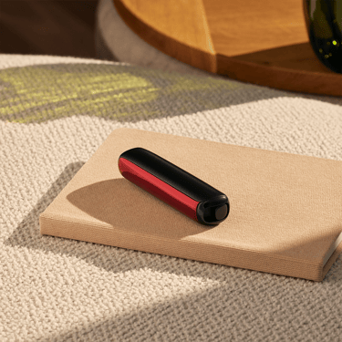Příslušenství Ploom AURA přední panel Lava Red nasazené na zařízení na stole