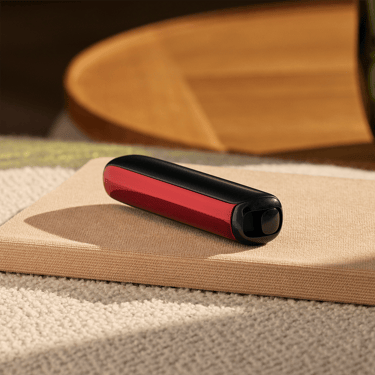 Příslušenství Ploom AURA přední panel Lava Red nasazené na zařízení na stole