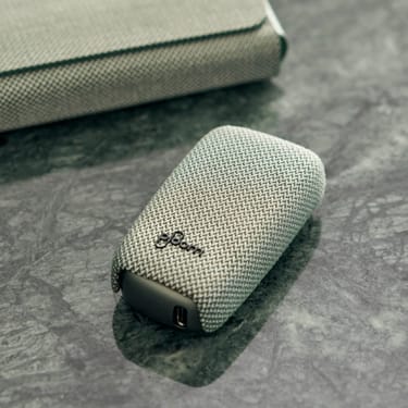Zařízení Ploom X  Advanced v zeleném, látkovém krytu na mramorovém pozadí